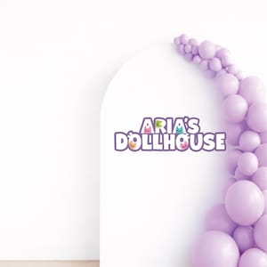 Può includere: Uno sfondo ad arco bianco con la scritta Aria's Dollhouse in lettere viola e piccole icone di gatti colorati integrate nel design. Un grappolo di palloncini color viola chiaro di varie dimensioni è fissato sul lato destro dell'arco.