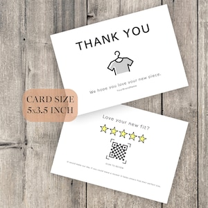 以下が含まれることがあります： 黒い文字と服のグラフィックが描かれた2枚の白いカード。1枚のカードには「THANK YOU」と「We hope you love your new piece」と書かれています。もう1枚のカードには、QRコードと星評価で「Love your new fit?」と書かれています。カードサイズは12.7 x 8.9 cmです。