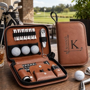 Könnte beinhalten: Ein braunes Golf-Zubehör-Etui aus Kunstleder mit Reißverschluss, innenliegenden elastischen Schlaufen für weiße Golftees, drei weißen Golfbällen und einer Pitchgabel aus Metall. Die Außenseite ist mit dem Namen Kenneth und dem Buchstaben K graviert.