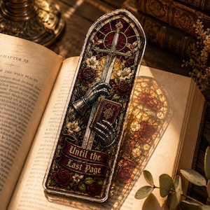 May include: A rectangular bookmark featuring a stained glass design with a sword held by armored gauntlets, a small book, and red roses. A dark red banner at the bottom displays the text Until the Last Page in gold lettering against a dark background.
