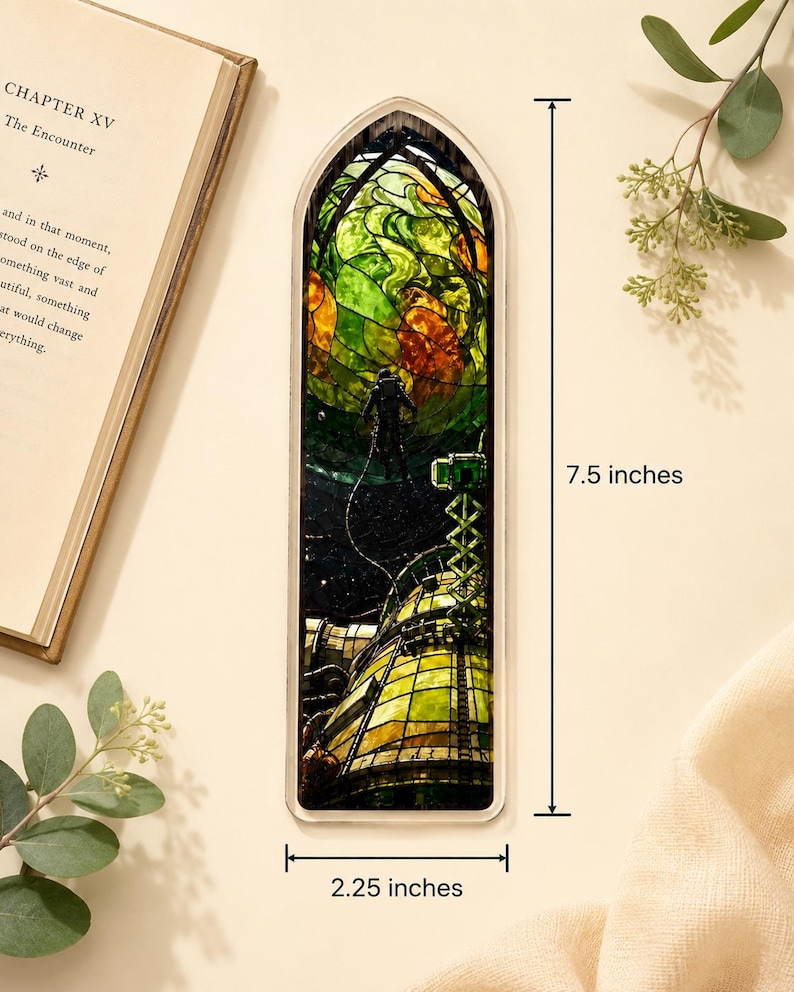 May include: A rectangular bookmark with a stained-glass design featuring an astronaut and a futuristic structure. The bookmark is 7.5 inches long and 2.25 inches wide. The design incorporates green, orange, and yellow hues, with a dark background.