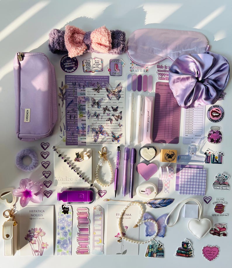 May include: An assortment of purple and lavender stationery and accessories, including a pencil case, pens, stickers, a headband, a sleep mask, a scrunchie, and decorative items. The items are arranged on a white surface.