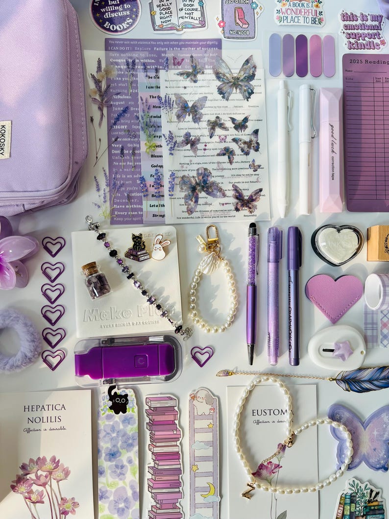 May include: An assortment of purple stationery and accessories, including pens, bookmarks, stickers, and a pencil case. The items feature butterfly and floral designs, with a cohesive aesthetic. A purple USB drive and a bracelet are also visible.
