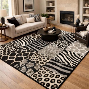 Può includere: Un grande tappeto con un design patchwork con stampe animalier. Il tappeto incorpora strisce zebrate, macchie di leopardo e altri motivi in bianco, nero e grigio. Il tappeto è collocato in un soggiorno con un divano e un tavolino.