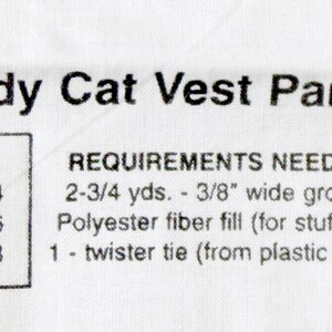 May include: White fabric panel with the text "Scaredy Cat Vest Panel." Includes sizing information for small (2-4), medium (5-6), and large (7-8). Also lists requirements: grosgrain ribbon, polyester fiber fill, and a twister tie.