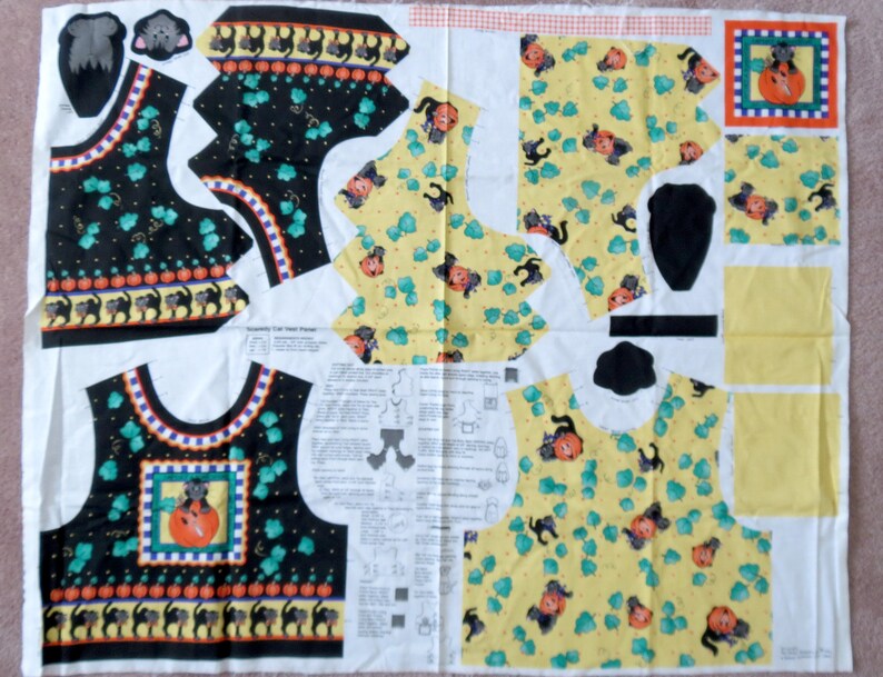 May include: A fabric panel with cut-out pieces for a Halloween-themed vest. The vest features black cats, pumpkins, and a cat in a pumpkin design. The background is black and yellow with green accents.