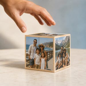 May include: A wooden photo cube puzzle featuring custom printed family photographs on each visible side. The cube displays images of a family at the beach and a family near a mountain lake, with light wood grain edges framing the individual photo panels.