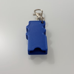 Puede incluir: Un accesorio de llavero azul impreso en 3D con un dise&ntilde;o ondulado. Cuenta con un cierre de metal plateado para sujetarlo a llaves o una bolsa. El llavero es de color azul vibrante.