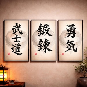 以下が含まれることがあります： 日本の書道が施された3つの額入りアートプリント。各プリントは、クリーム色の背景に黒い筆致が特徴で、文字の後ろに円形のデザインがあります。フレームは黒で、プリントは壁に表示されています。