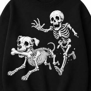 Könnte beinhalten: Ein schwarzes Sweatshirt mit Rundhalsausschnitt und einem weißen Grafikdruck, der ein menschliches Skelett zeigt, das neben einem Hundeskelett rennt. Das Hundeskelett hält einen großen Knochen im Maul, während das menschliche Skelett einen Arm ausstreckt.