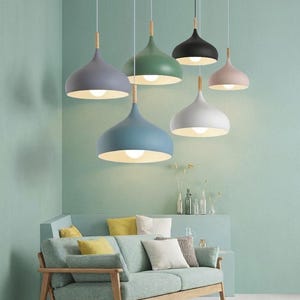 Könnte beinhalten: Ein Set aus drei Keramikbechern mit gesprenkelter, matter Oberfläche. Die Becher sind in Creme-, Hellgrau- und Dunkelgrautönen gehalten. Jeder Becher hat ein schlichtes, minimalistisches Design.