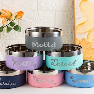 Può includere: Una collezione di sei ciotole rotonde per animali in acciaio inossidabile con esterni opachi colorati. Le ciotole presentano nomi e icone incisi come Molld, Flash, Crush, Daisy, Smith e cookie in colori come grigio, viola, turchese, blu navy, rosa e azzurro.