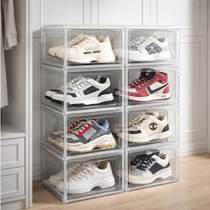 May include: A white ceramic mug with a black handle and the text "But First, Coffee" in a bold, black font. The mug is set against a blurred background, suggesting a cozy setting.