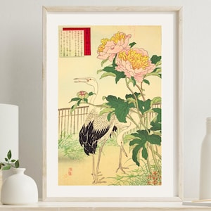 May include: Framed Japanese-style art print featuring two cranes and pink and yellow peonies. The artwork has a light yellow background with a small fence and green foliage. A red and white text box is in the upper left corner.