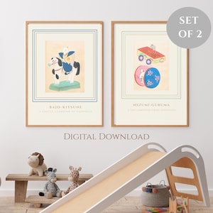 以下が含まれることがあります： 2つの額入りアートプリントのセット。1つは馬に乗ったキツネ、もう1つはおもちゃを持ったネズミが描かれています。プリントはベージュの背景に青と緑のアクセントがあります。下部のテキストは「BAJO-KITSUNE」と「NEZUMI-GURUMA」と書かれています。