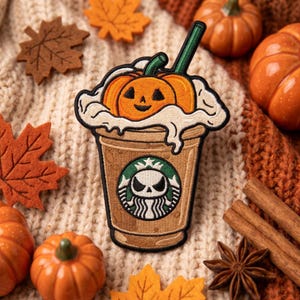 May include: An embroidered patch shaped like a coffee cup topped with whipped cream and a jack-o'-lantern. The cup features a circular logo with a white skull design on a green background. The patch has a black border and is stitched with tan, orange, white, and green thread.