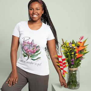 May include: White scoop-neck t-shirt with a floral design and the word "Bloom". The floral design features pink, purple, and green colors. The text "root of sonder 'n pot" is also printed on the shirt. The shirt is paired with gray pants.