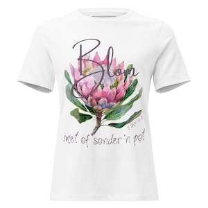 May include: White t-shirt featuring a watercolor illustration of a pink protea flower with green leaves and the word "Blom" in a script font. The text "met of sonder 'n pot" is below the flower.