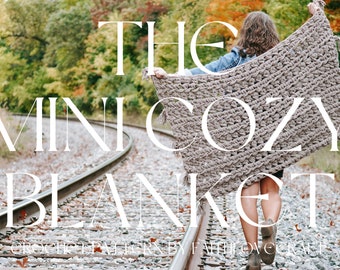 May include: A woman walks on a railroad track holding a large, brown, crocheted blanket. The text "THE MINI COZY BLANKET" is superimposed on the image.