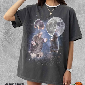 Op de afbeelding: Een antracietgrijs T-shirt met korte mouwen en een grafische print van drie mollen in een sterrenhemel met een grote volle maan. Het T-shirt heeft een ronde hals en een relaxte pasvorm. De tekst Color Shirt Pepper staat linksonder afgedrukt.