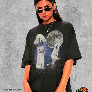 May include: Black t-shirt featuring a graphic of white ferrets against a starry background and a full moon. The shirt has the text "Color Shirt Black" at the bottom left.