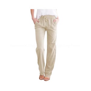 Puede incluir: Pantalones beige de pernera ancha con cintura con cordón. Los pantalones tienen bolsillos y un corte relajado. La modelo lleva un top blanco y sandalias. Los pantalones son de tejido ligero.