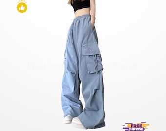 May include: Light blue cargo pants with multiple pockets and a drawstring waist. The pants have a wide leg design and are paired with white sneakers. The overall style is casual and relaxed.