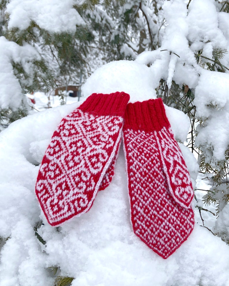 Red and white colorwork mittens on snow