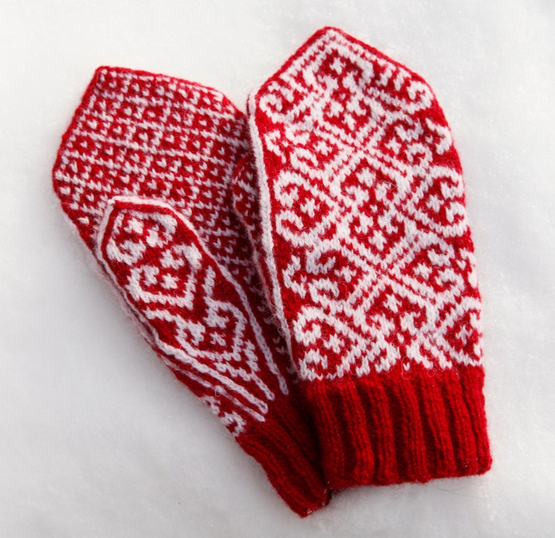 Red and white colorwork mittens on snow