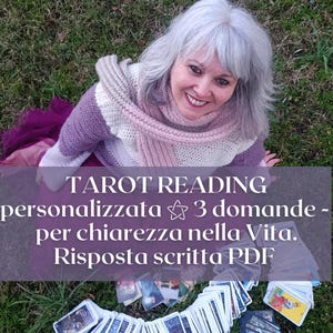 Può includere: Una donna con i capelli grigi sorride, indossa una sciarpa e un maglione rosa, viola e bianco. La sovrapposizione di testo recita "TAROT READING personalizzata 3 domande - per chiarezza nella Vita. Risposta scritta PDF" con carte dei tarocchi in primo piano.
