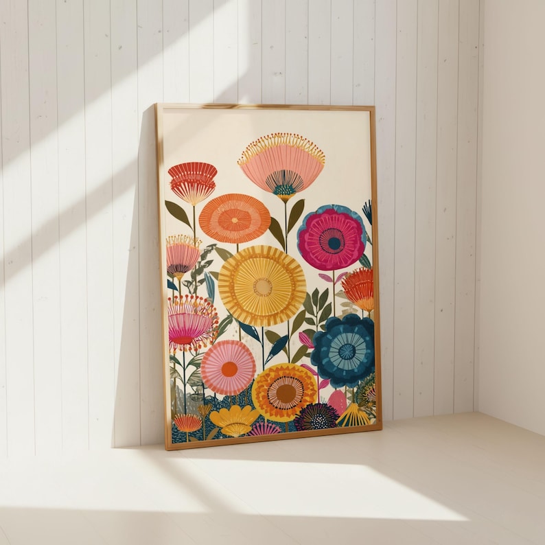 May include: A framed floral art print featuring a vibrant array of stylized flowers. The artwork showcases blooms in shades of pink, orange, yellow, and blue, set against a cream background. The print is encased in a light brown wooden frame.