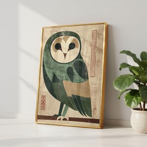 Op de afbeelding: Ingelijste kunstdruk met een gestileerde uil-illustratie. De uil is afgebeeld in tinten groen, beige en bruin tegen een textuurachtergrond. Het kunstwerk is ingelijst in een goudkleurige lijst en leunt tegen een witte muur.