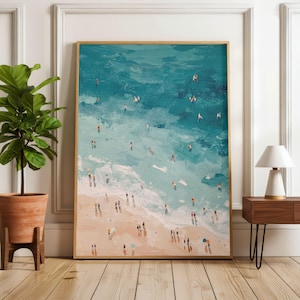 Puede incluir: Pintura abstracta enmarcada de una escena de playa. La obra representa una playa arenosa que se encuentra con agua turquesa, con pequeñas figuras de personas en la playa y en el mar. La pintura tiene un estilo texturizado, con pinceladas, y un marco de madera.