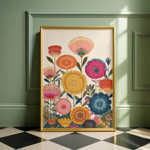 May include: A framed floral art print featuring colorful stylized flowers in shades of pink, orange, yellow, and blue. The artwork is set against a cream background and framed in gold. The print is displayed against a green wall.