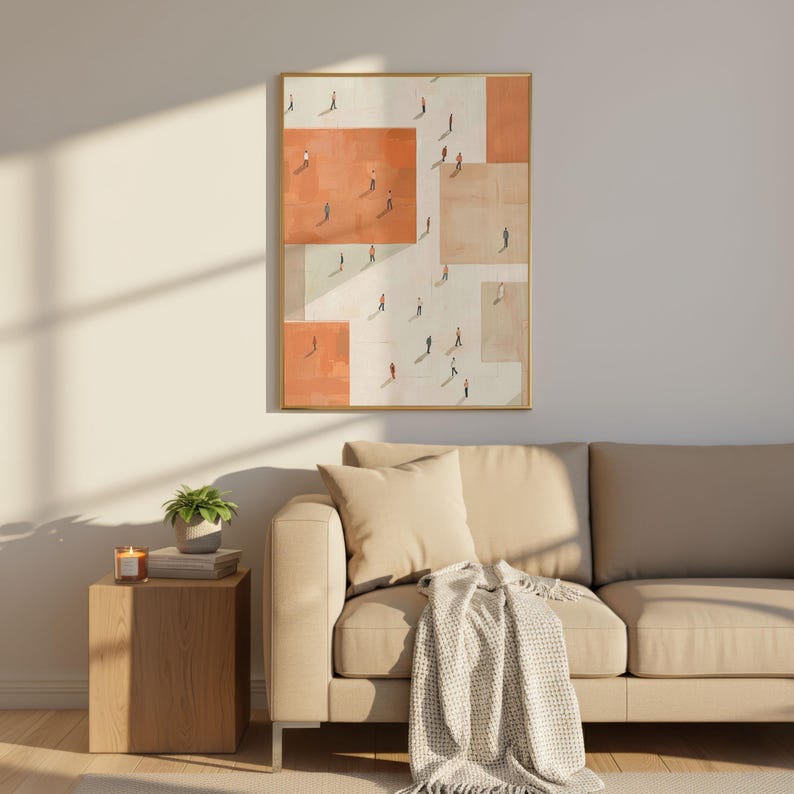 May include: An abstract framed art print featuring a geometric design with orange and beige blocks. Small figures are depicted walking within the blocks. The artwork is displayed above a beige sofa with pillows and a blanket, next to a wooden side table.