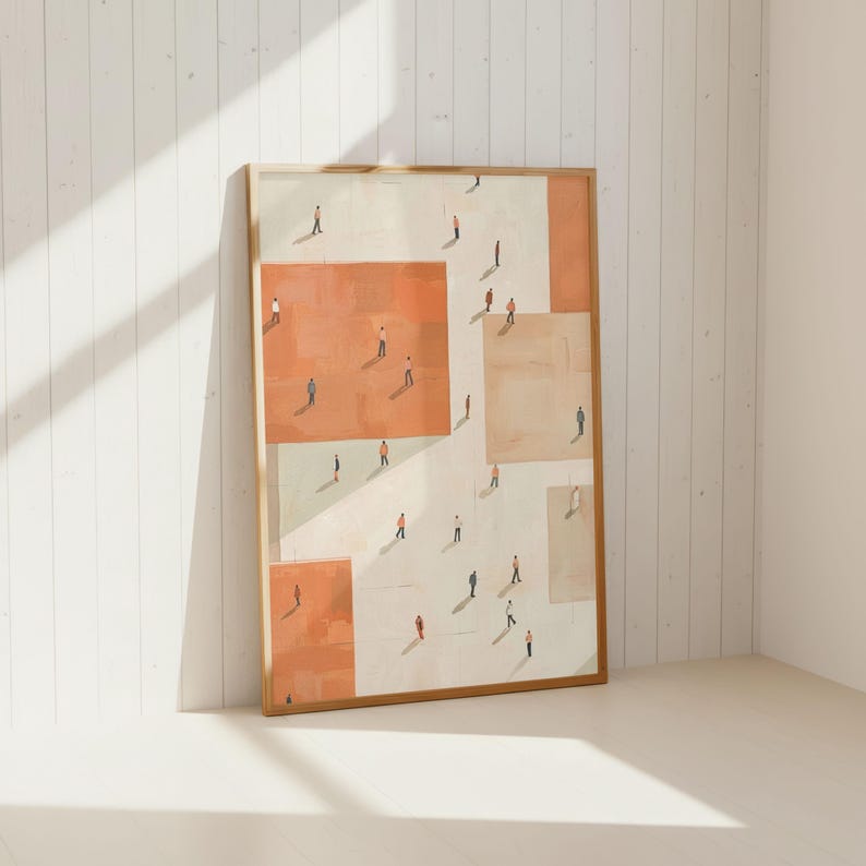 May include: Framed art print featuring an abstract design of people on geometric shapes in shades of orange, beige, and white. The artwork is displayed in a light-colored wooden frame, leaning against a white wall.