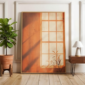 Può includere: Una stampa artistica incorniciata raffigurante una finestra astratta nei toni caldi dell'arancione e del beige. Il design include un motivo a griglia e una silhouette di pianta. L'opera d'arte è esposta in una stanza con una pianta e una lampada, creando un'estetica minimalista.