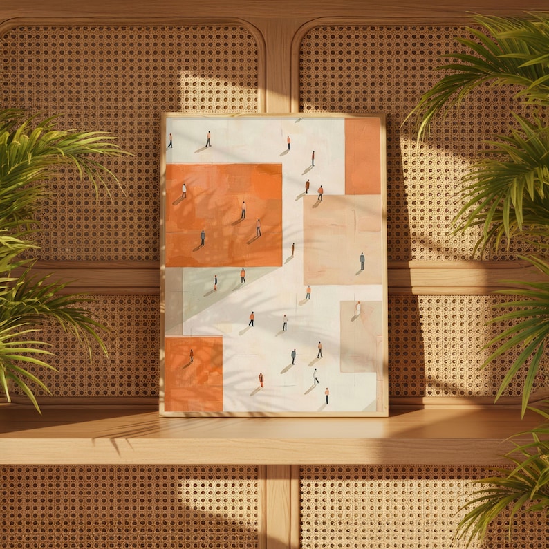 May include: A framed art print featuring an abstract design with geometric shapes in shades of orange, white, and beige. Small figures are scattered across the surface, creating a sense of scale and depth. The artwork is displayed on a wooden shelf.