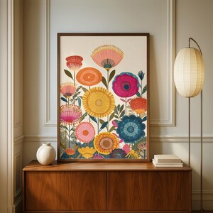 May include: A framed floral art print featuring a vibrant array of stylized flowers in shades of pink, orange, yellow, and blue. The artwork is set against a cream background and framed in a dark wood. The print is displayed on a wooden cabinet.