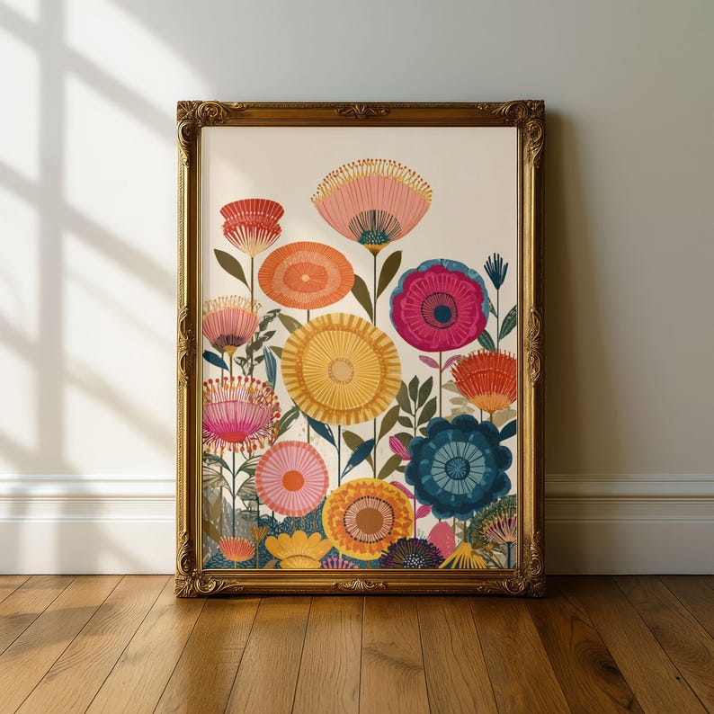 May include: A framed floral art print featuring colorful, stylized flowers in shades of pink, orange, yellow, and blue. The artwork is set against a cream background and framed in a gold ornate frame. The print is displayed on a wooden floor.