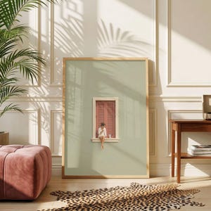 Könnte beinhalten: Ein rechteckiger Wandkunstdruck mit salbeigrünem Hintergrund und einer mittigen Illustration eines kleinen Fensters mit geschlossenen terrakottafarbenen Fensterläden. Eine Person sitzt auf dem Fenstersims und hält eine kleine silberne Kaffeekanne.