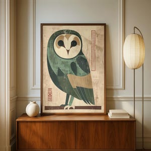 Op de afbeelding: Een ingelijste kunstdruk met een gestileerde uil in groen, beige en bruin. De uil is afgebeeld met geometrische vormen en patronen. Het kunstwerk wordt tentoongesteld op een houten kast, met een lamp en een vaas in de buurt.