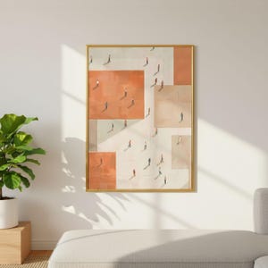 May include: Framed abstract art print featuring a geometric design with orange, beige, and white blocks. Tiny figures are scattered throughout the blocks, creating a sense of depth and scale. The artwork is encased in a gold frame.