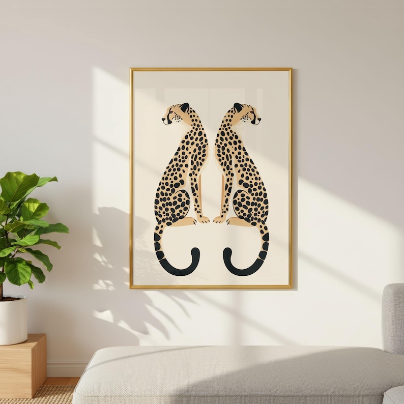 May include: A framed art print featuring two stylized cheetahs facing each other. The cheetahs have tan bodies with black spots and black curved tails. The artwork is set against a cream background and framed in gold.
