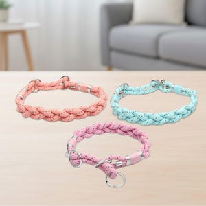 May include: Three braided dog collars in pastel colors: peach, light blue, and pink. Each collar has silver-tone hardware and a matching leash ring. The collars are made of a soft, durable rope material.