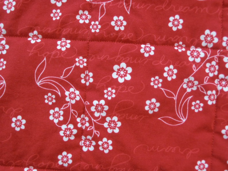 May include: Red fabric with a white floral pattern and the words "Hope" and "Dream" repeated throughout.