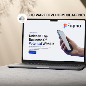 May include: A silver laptop displaying a website with the Figma logo and the text "Unleash The Business Of Potential With Us." The screen shows a hand holding a smartphone. The laptop is on a gray surface.