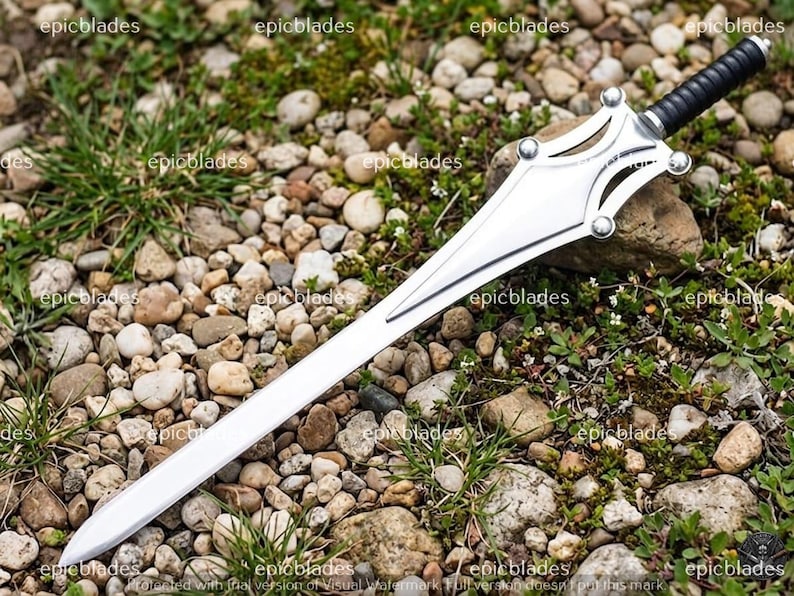 May include: A silver-colored sword with a pointed blade and a decorative guard featuring four circular accents. The handle is black with a ribbed texture and a silver pommel. The word epicblades is repeated across the image as a watermark.