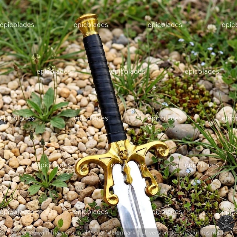 May include: A sword featuring a black wrapped handle, a gold-colored crossguard with a skull detail, and a metallic blade. The word epicblades is repeated across the image as a watermark. The sword is positioned vertically with the hilt at the top.