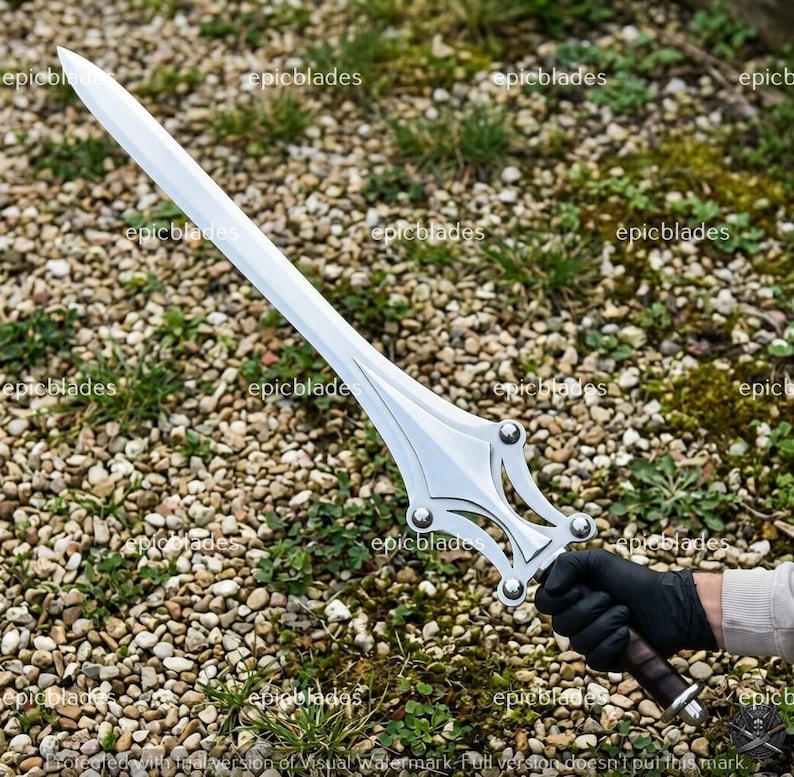 May include: A silver-colored metal sword with a pointed blade and a decorative crossguard featuring four circular rivets. The handle is wrapped in dark material, and the blade has a central ridge running down its length. The word epicblades is visible.